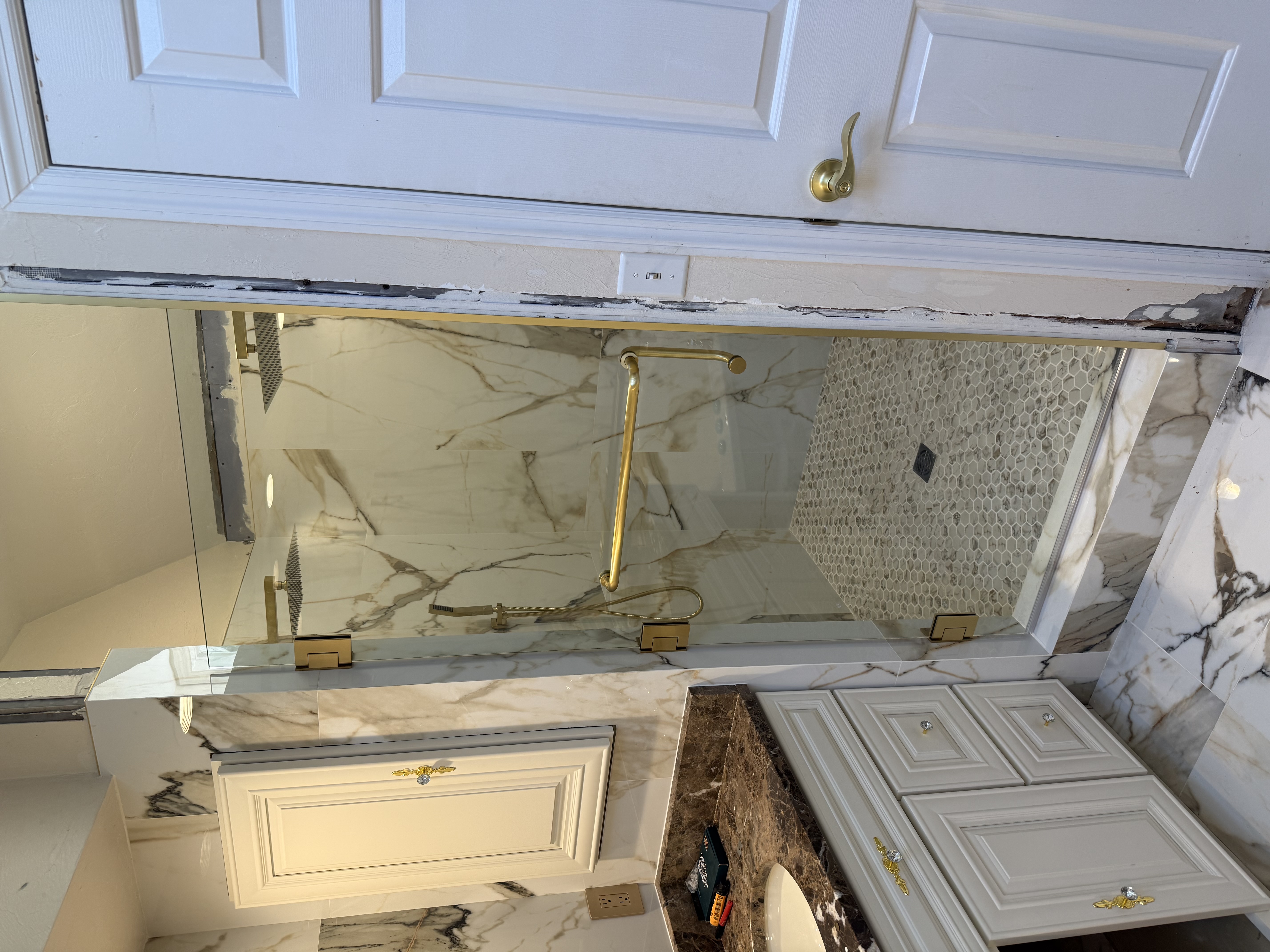 Frameless heavy glass hinge door with satin brass